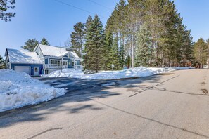A residential house with a garage, surrounded by snow and tall pine trees. - Family Escape in Crystal Mtn Resort! 13 Mi to Lake (Thompsonville)