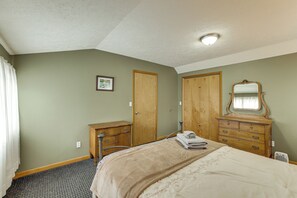 A bedroom with a bed, dresser, mirror, and two doors. - Family Escape in Crystal Mtn Resort! 13 Mi to Lake (Thompsonville)
