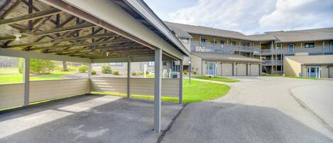 A covered parking area with a building in the background.