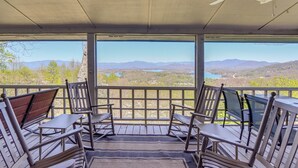 Un área de estar al aire libre con techo, con sillas y mesa de madera, con vistas a un paisaje pintoresco.