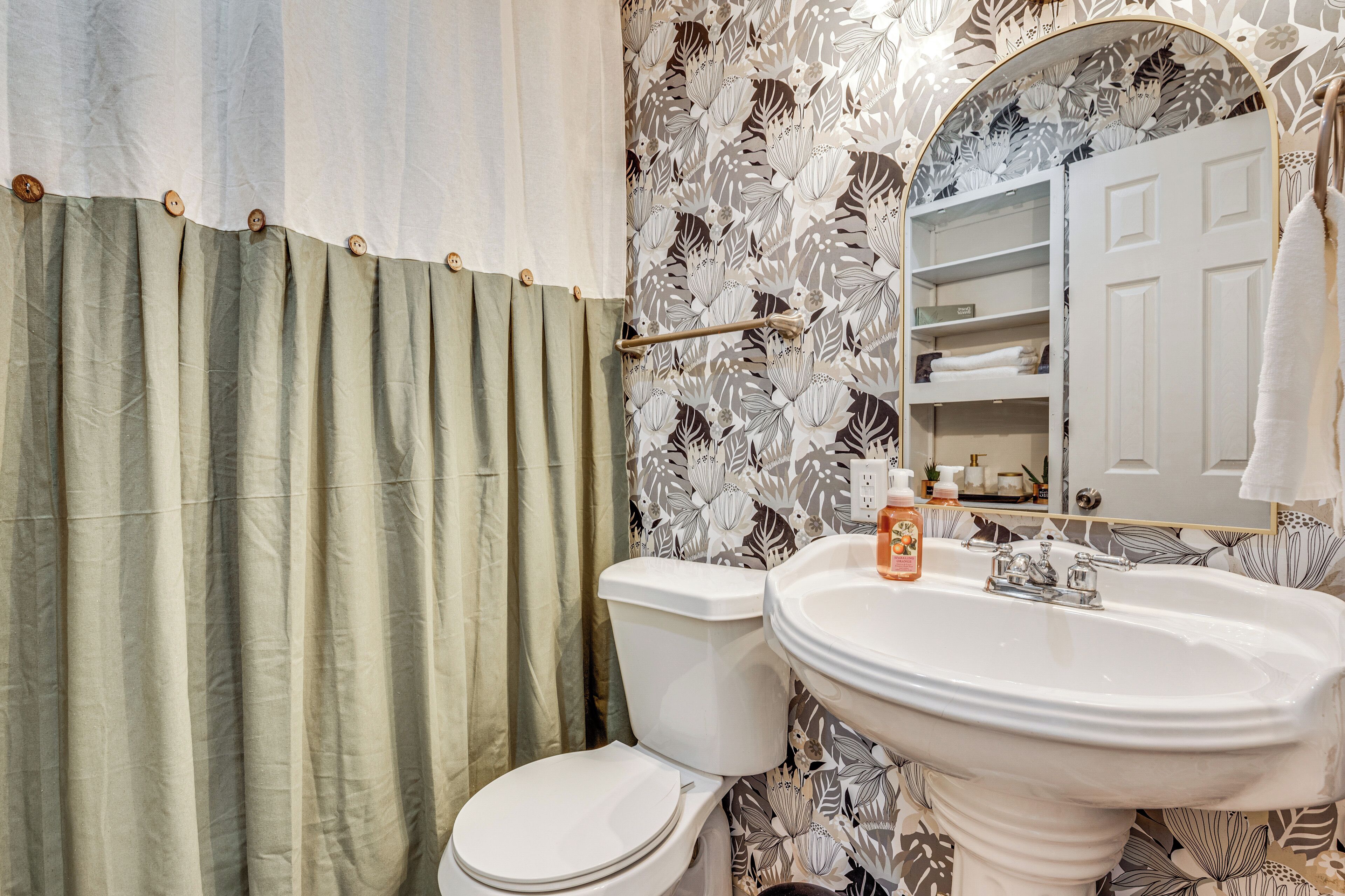 Une salle de bain équipée de toilettes, d’un lavabo et d’un rideau de douche.