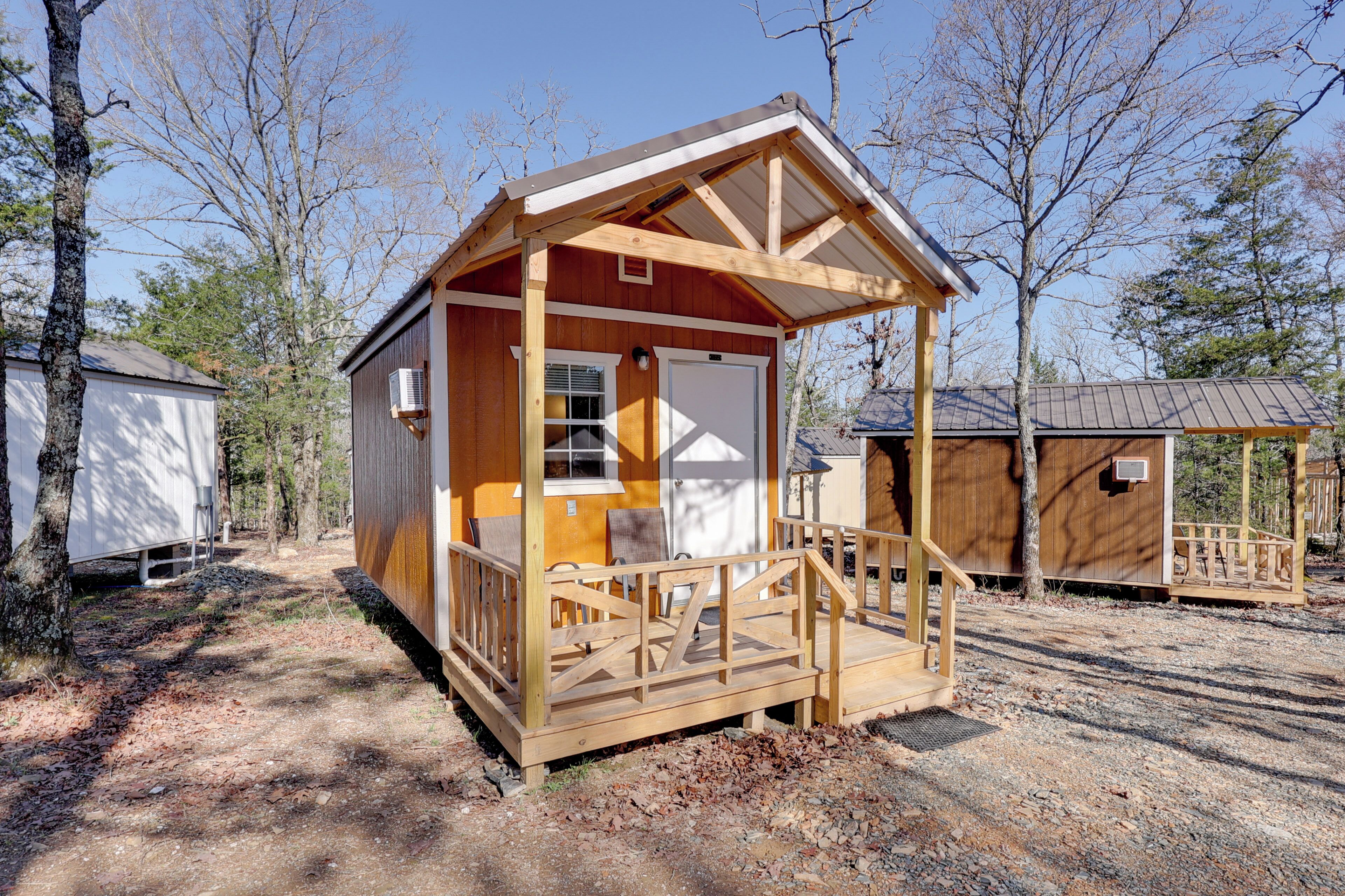 A small wooden cabin with a porch, a door, and a window.