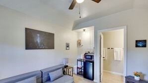 Un salon moderne avec un canapé, une petite table, un four à micro-ondes et une cheminée.