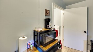 A compact kitchen with a microwave on a wooden countertop, a coffee maker, and a roll of paper towels. - Small Family Getaway in Mena w/ Trails On-site! (Mena)