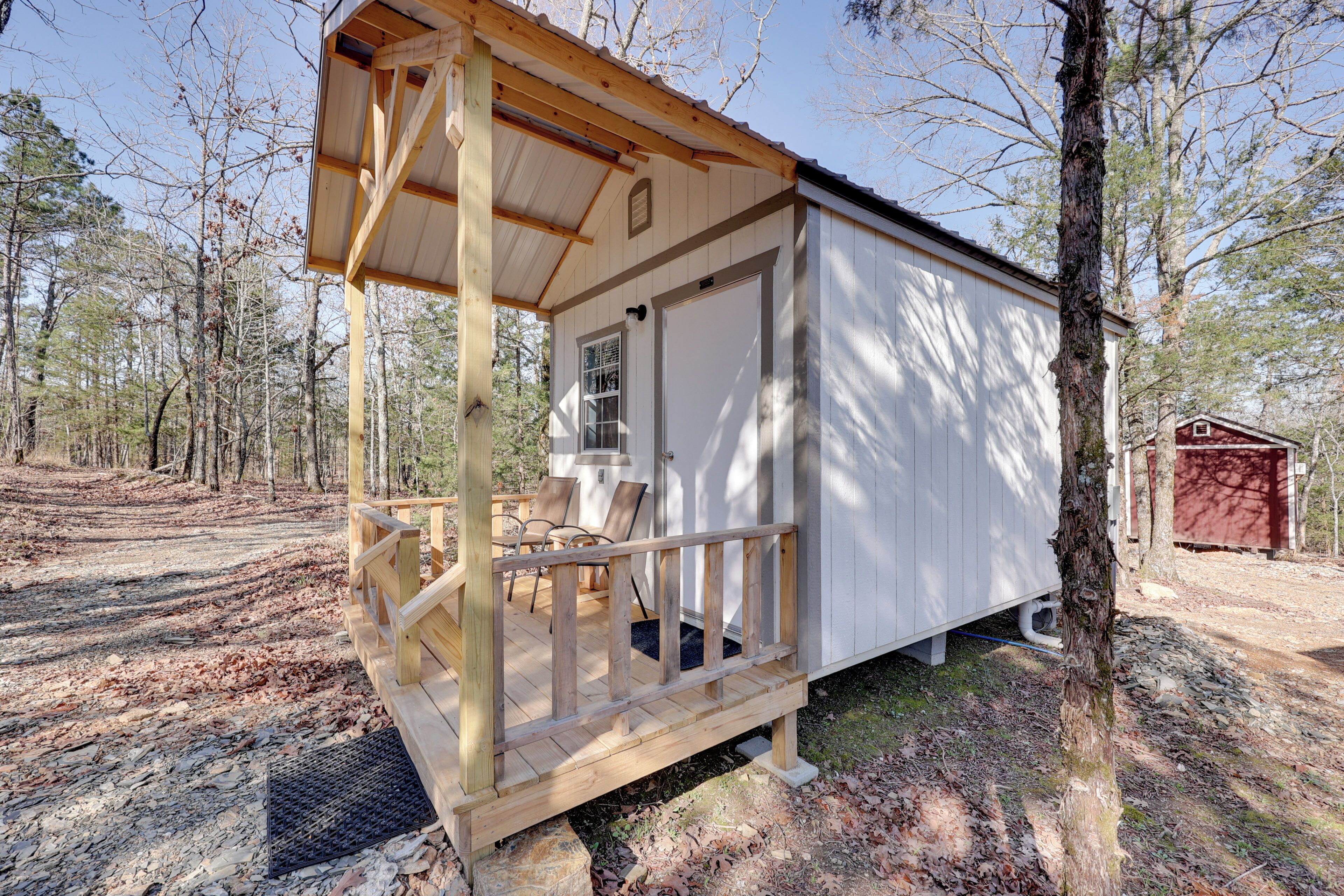 A small cabin with a porch, a door, and a window.