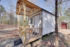 A small cabin with a porch, a door, and a window. - Gem Mine & Hike! Unique Stay in Ouachita Mountains (Mena)