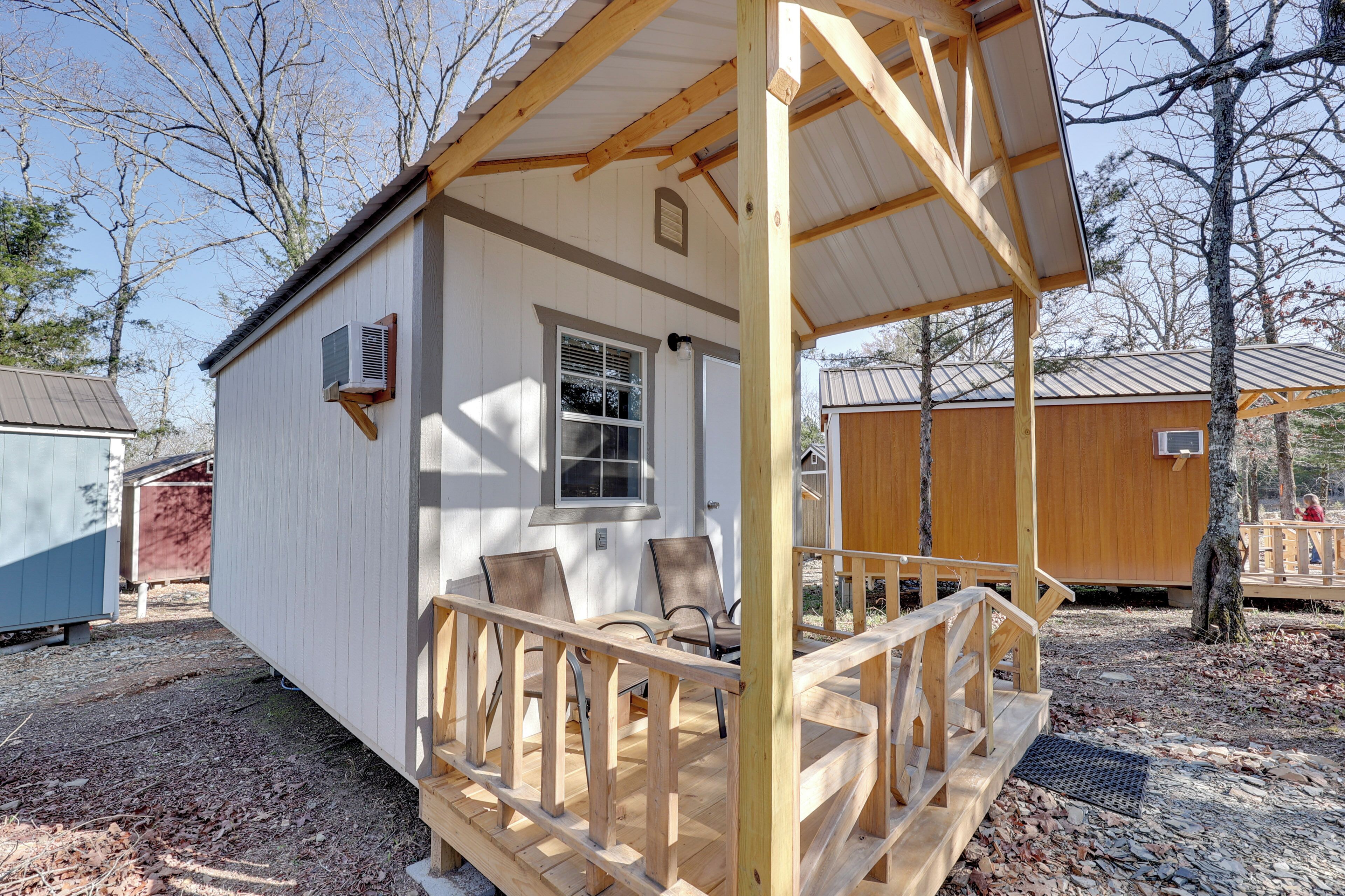 A small cabin with a porch, a window, and a door.