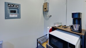 A kitchenette with a microwave, coffee maker, and electrical outlet. - Ouachitas Adventure Base! Charming Tiny Cabin (Mena)