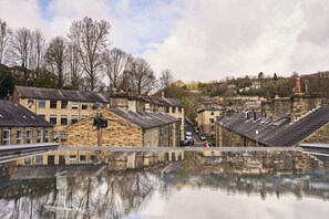 Eine historische Stadt mit Steinhäusern, blauem Himmel und Spiegelungen in einer Pfütze.