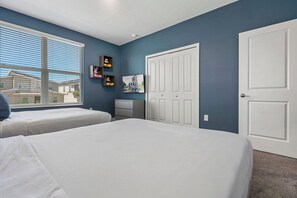 A bedroom with two beds, a window, a dresser, and a door. - 5BR•Sleeps 13•Pvt pool & spa•Free water park (Kissimmee)