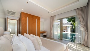 Een moderne slaapkamer met een groot bed, een wandpaneel van hout, een bureau en uitzicht op een zwembad.