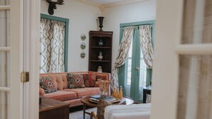 A cozy living room with a sofa, a coffee table, and a bookshelf. - Charming cottage on 8 acres of peace & tranquility just a short drive from town. (Boaz)