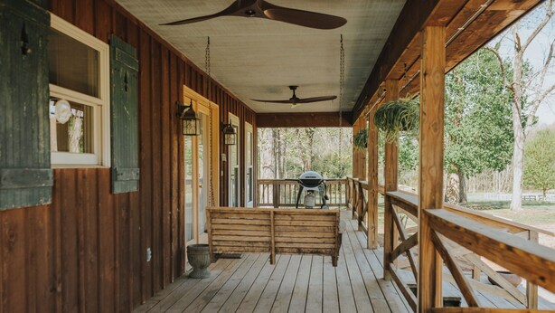A wooden porch with a ceiling fan, a bench, and a grill area. - Charming cottage on 8 acres of peace & tranquility just a short drive from town. (Boaz)