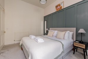 A bedroom with a bed, bedside tables, a radiator, and a framed picture on the wall. - Stockbridge ‘Little Gem’ Flat, Sleeps 3 (Stockbridge)