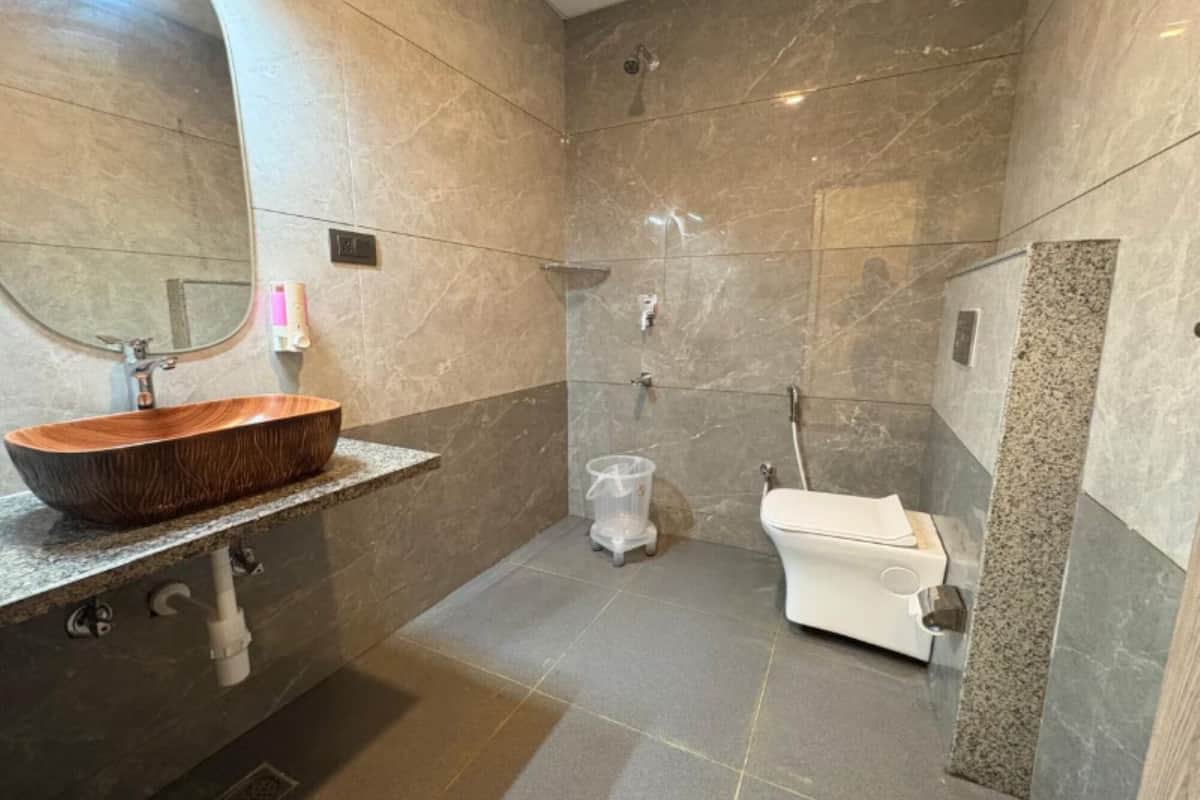Un baño moderno con un lavabo de madera, inodoro y zona de ducha.