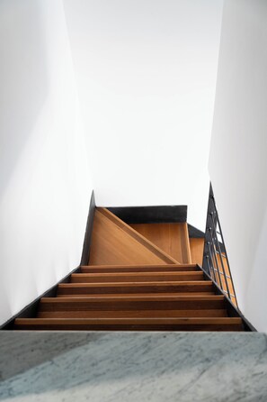 A staircase with wooden steps and a metal railing, leading to a landing with a wooden floor. - ✨ Apartment in the center, quiet and well served by public transportation (Genova)