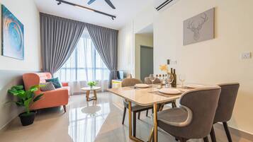 A modern living room with a dining area, a ceiling fan, and a large window with curtains.