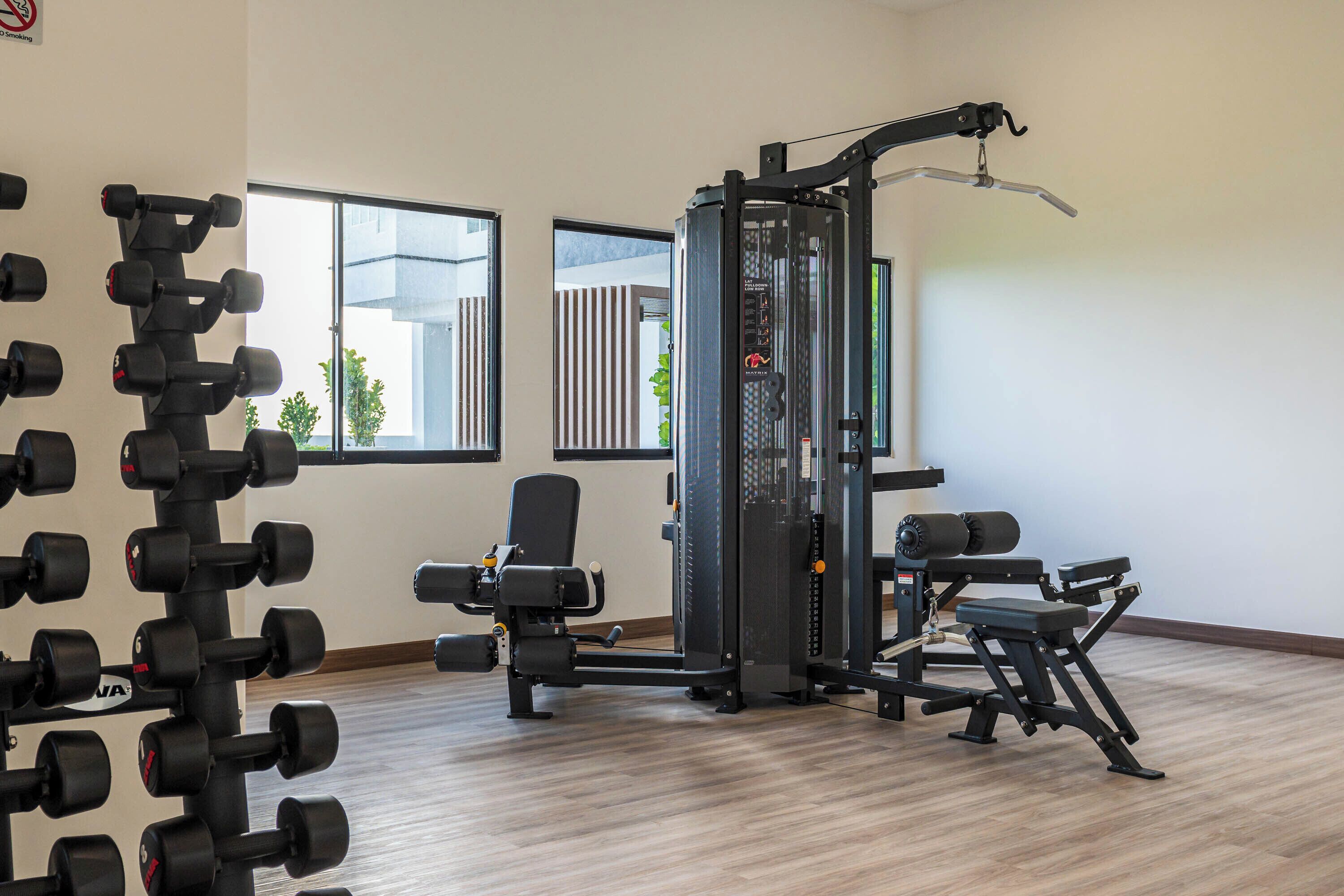 Ein Fitnessraum mit Krafttrainingsgeräten, Hanteln und einer Bank.