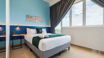 A neatly made bed with a green throw, a wall-mounted artwork, and a window with curtains.