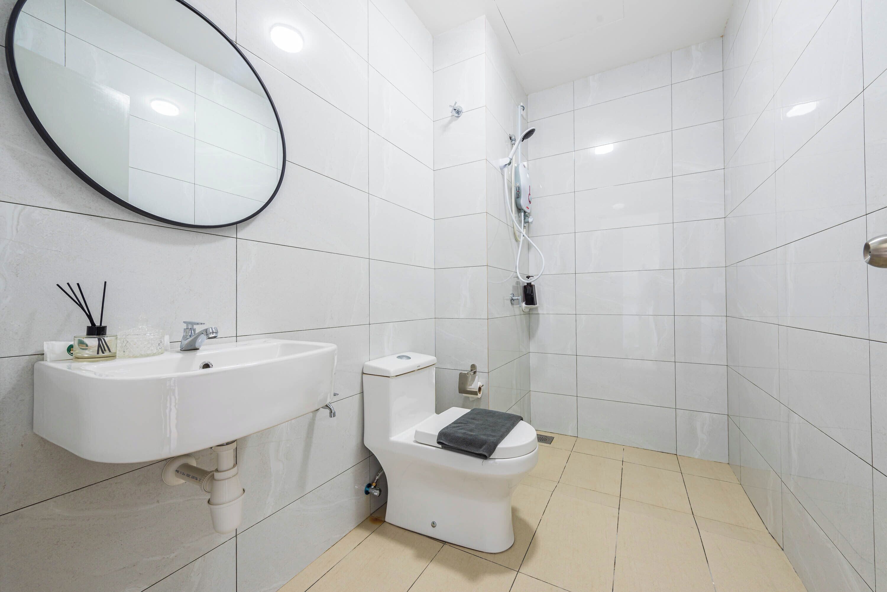 A bathroom with a white sink, toilet, and shower.