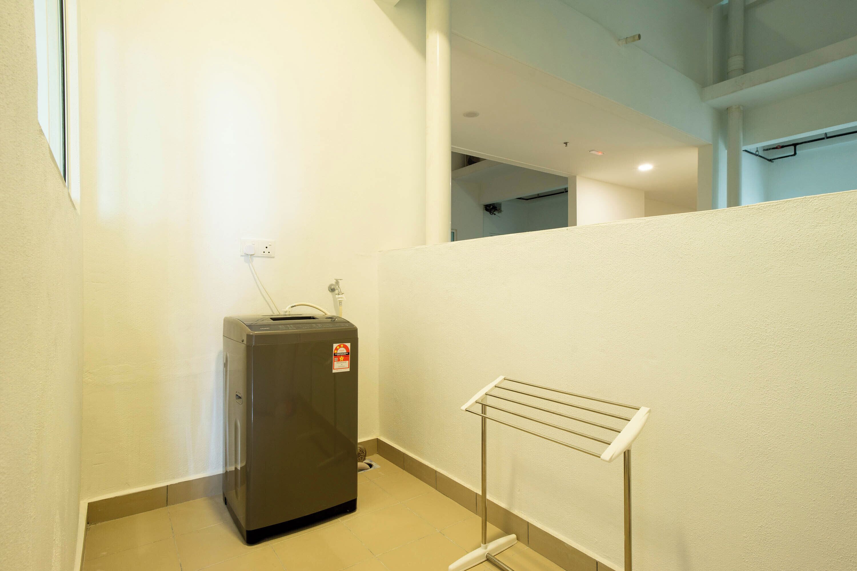 Una habitación compacta con un calentador en la pared, un perchero y un ventanal visible.