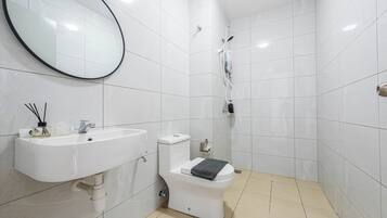 A bathroom with a white sink, toilet, and shower.