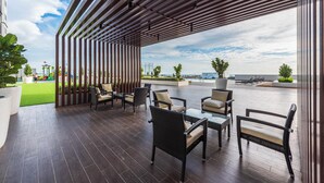 Un espacio exterior con mobiliario de mimbre y vista al mar.