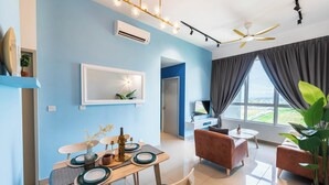 Una sala de estar moderna con comedor, ventilador de techo y un amplio ventanal con cortinas.