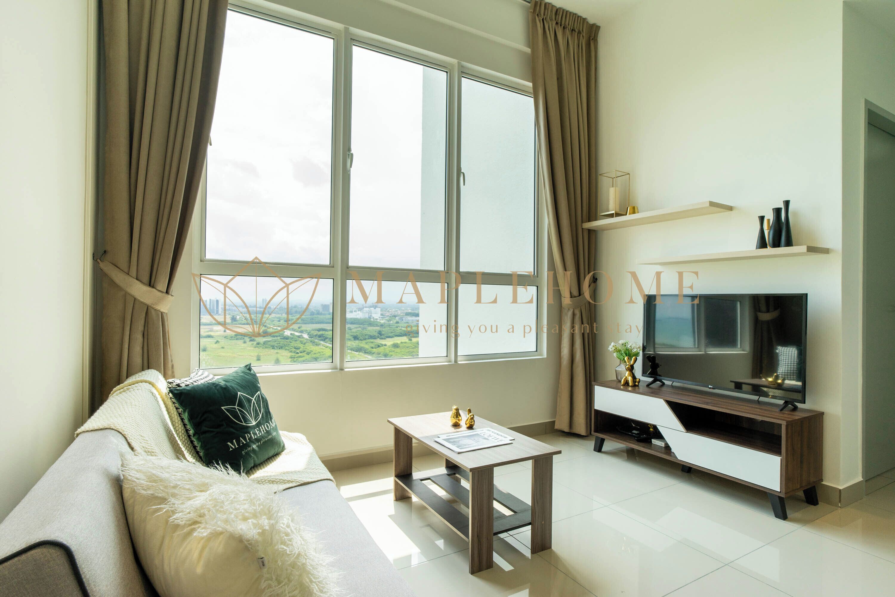 Una sala de estar con un sofá, una mesa de centro, un televisor y una ventana con cortinas.