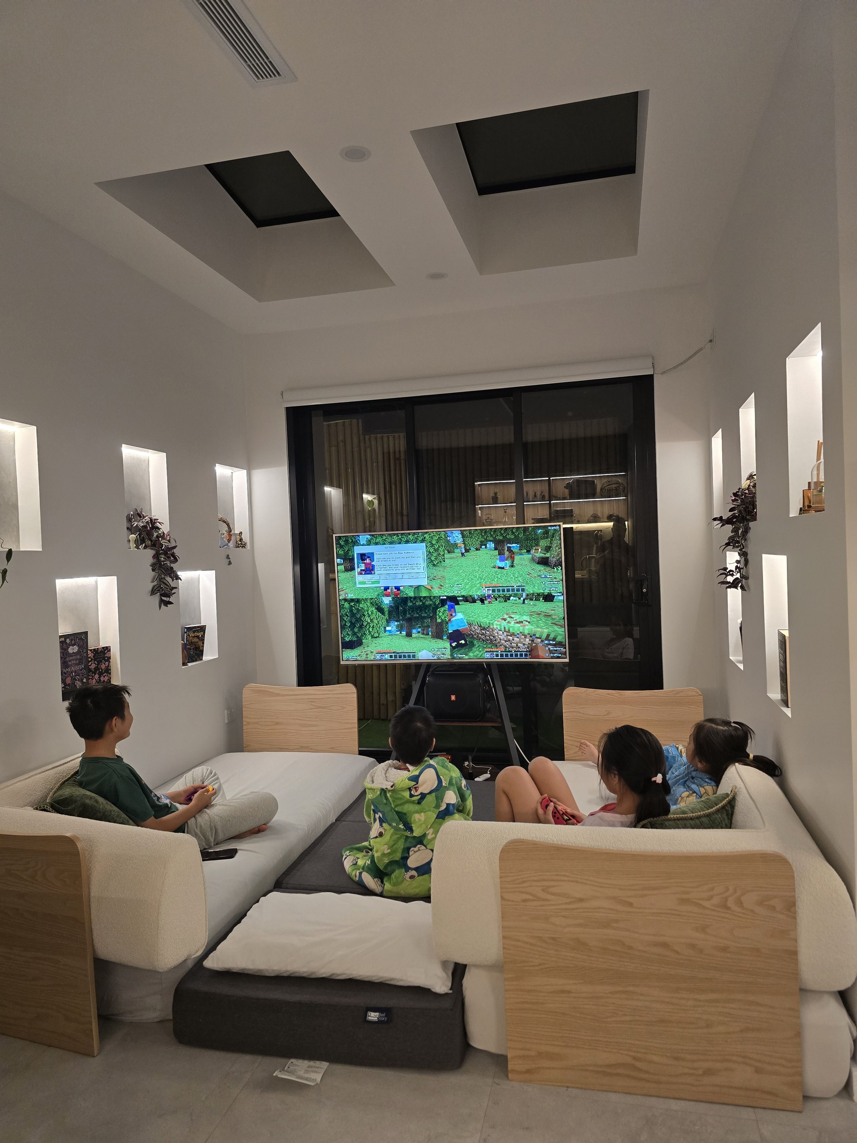 Un salon moderne doté d’un téléviseur à écran plat, de sièges confortables et d’un design minimaliste.