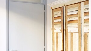 A white door with a silver handle and a wooden door with a distressed finish and visible hinges. - Hosmate - Milano - Vespri Siciliani- Blu Mare (Milano)
