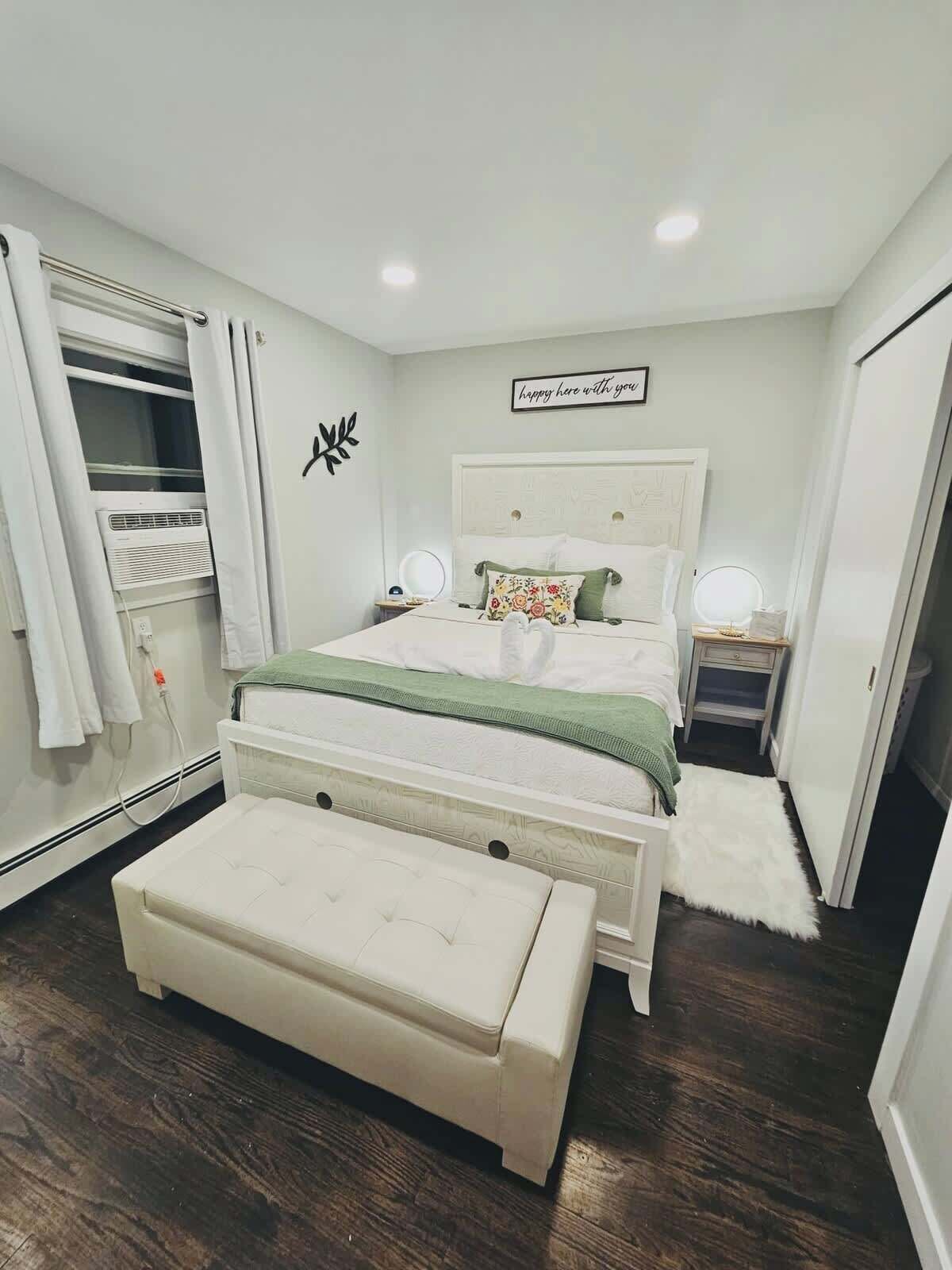A bedroom with a bed, a bench, a wardrobe, and a wall decoration.