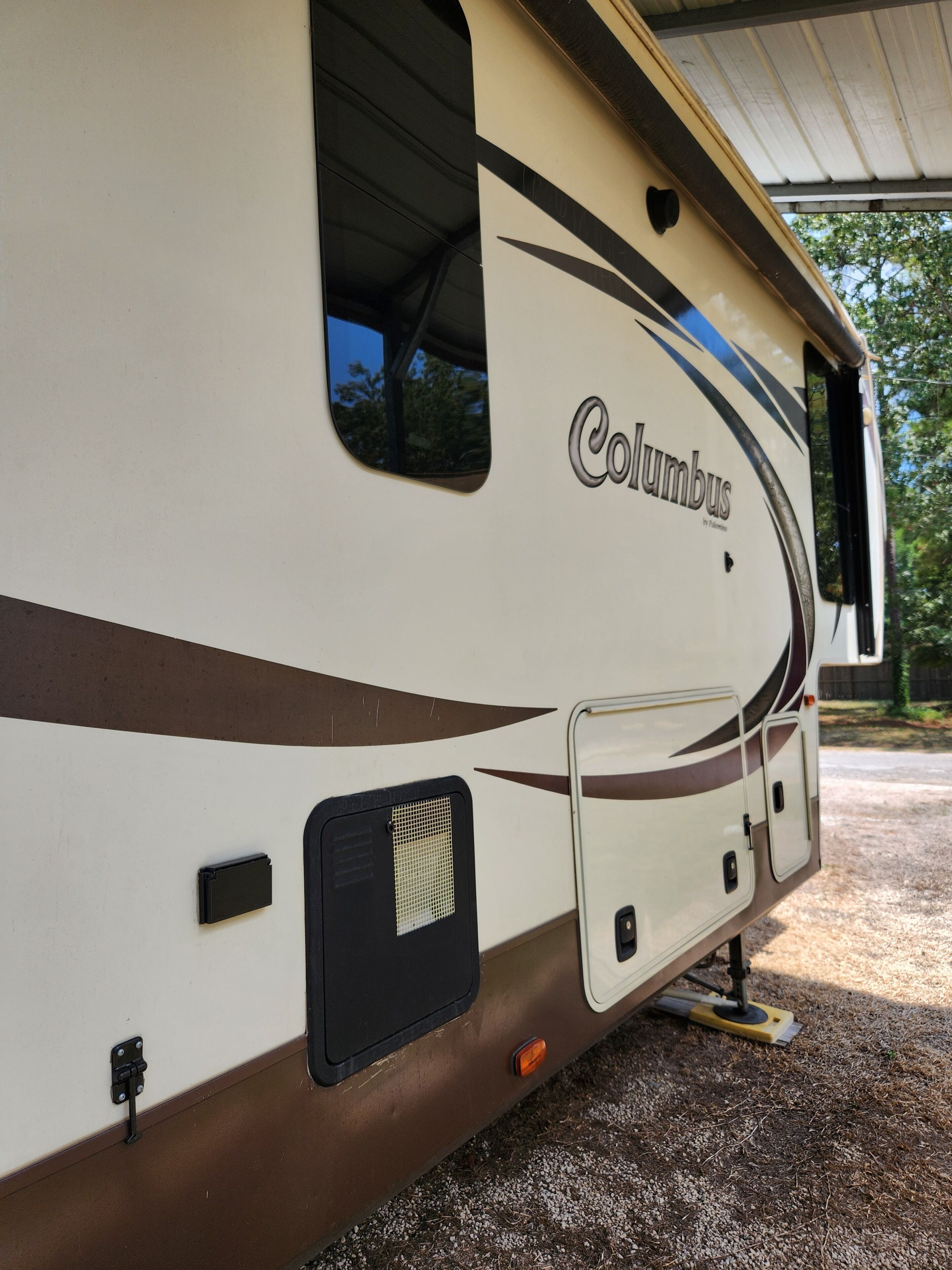 A white RV with 'Columbus' branding, a sliding door, and a small window.