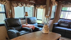A kitchen area with a countertop, cabinets, and a blender. - Beautiful 5th wheel with 4 slides in point blank (Point Blank)
