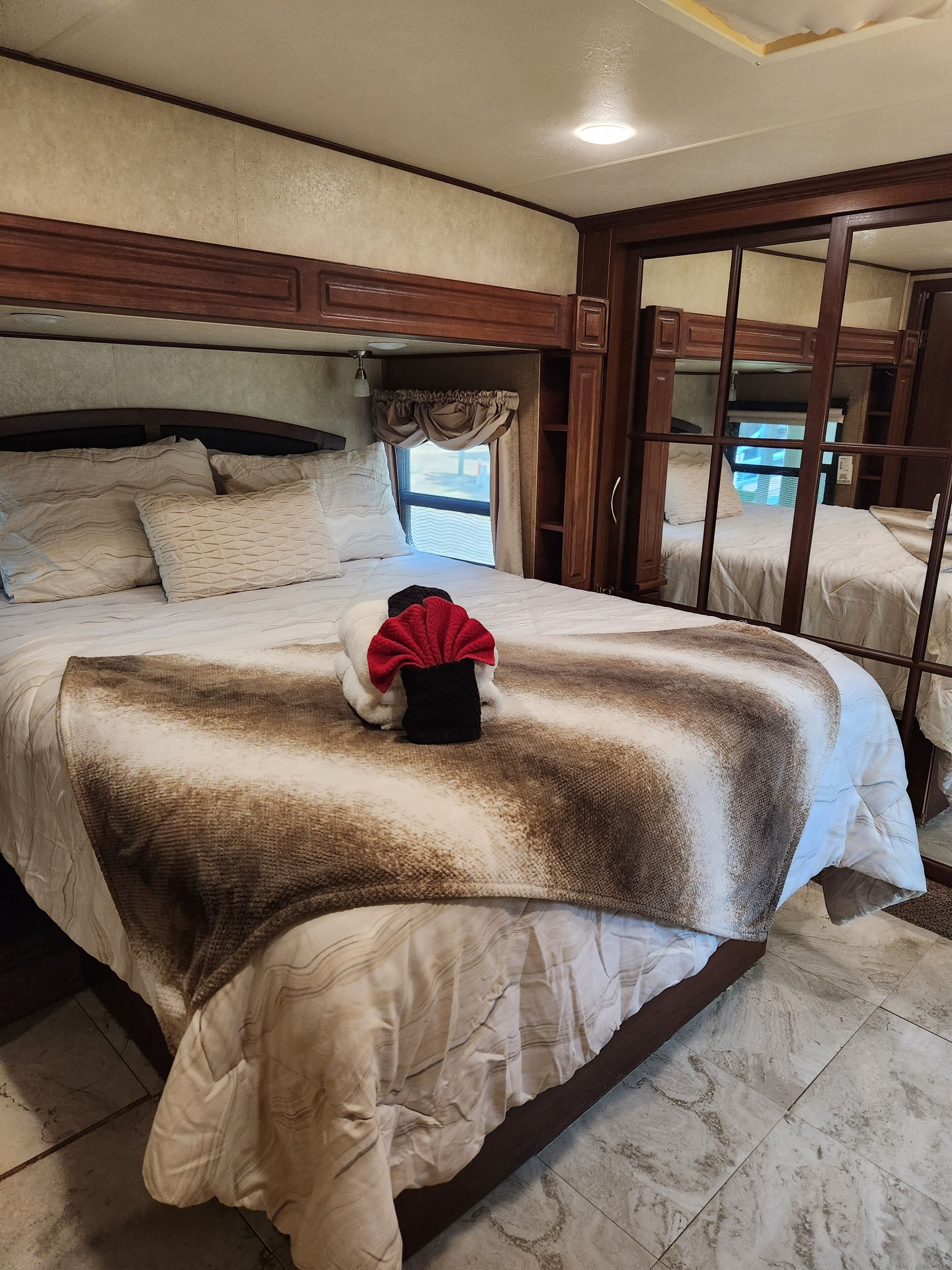 Une chambre avec un grand lit, une fenêtre avec des rideaux et une vue sur l’extérieur.