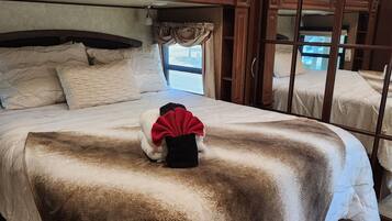 Une chambre avec un grand lit, une fenêtre avec des rideaux et une vue sur l’extérieur.