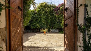 A courtyard with stone flooring, a potted plant, and a bench. - Tenuta Donna Vittoria Bouganville Apartment with Mountain View, Wi-Fi & Air Conditioning (Trapani)