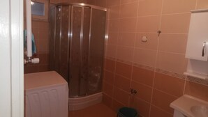 A bathroom with a shower, toilet, sink, and a small window. - Quiet and Comfortable in Sinop Karakum Site 2 (Sinop)