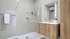 A modern bathroom with a glass shower enclosure, a wooden vanity, and a large mirror. - Mosta Couples Retreat - Sunny Rooftop 2BR (Il-Mosta)