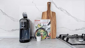 A kitchen with a gas stove, a black electric kettle, a wooden cutting board, and a cookbook titled 'Vegetarian.' - Mosta Couples Retreat - Sunny Rooftop 2BR (Il-Mosta)