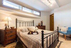 A bedroom with a bed, a nightstand, a dresser, a chair, a window, and a door. - Epidavros Villas - Voukamvilia Retreat w Pool (Epidaurus)