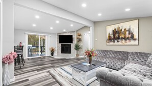 Una sala moderna con un sofá gris, una mesa de centro y una chimenea.