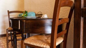 A wooden dining table with a plate, a cup, and a decorative item. - Apartment 'Tenuta Donna Vittoria Mandarino' with Mountain View, Wi-Fi and Air Conditioning (Trapani)