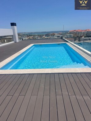 A rooftop swimming pool with a clear view of the cityscape in the background. - Beautiful 2 bedroom/2 bath Luxury Apartment with Pool and Sea view (Lagos)