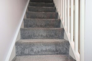 A staircase with carpeted steps and white railings. - Trelowen (Wadebridge)