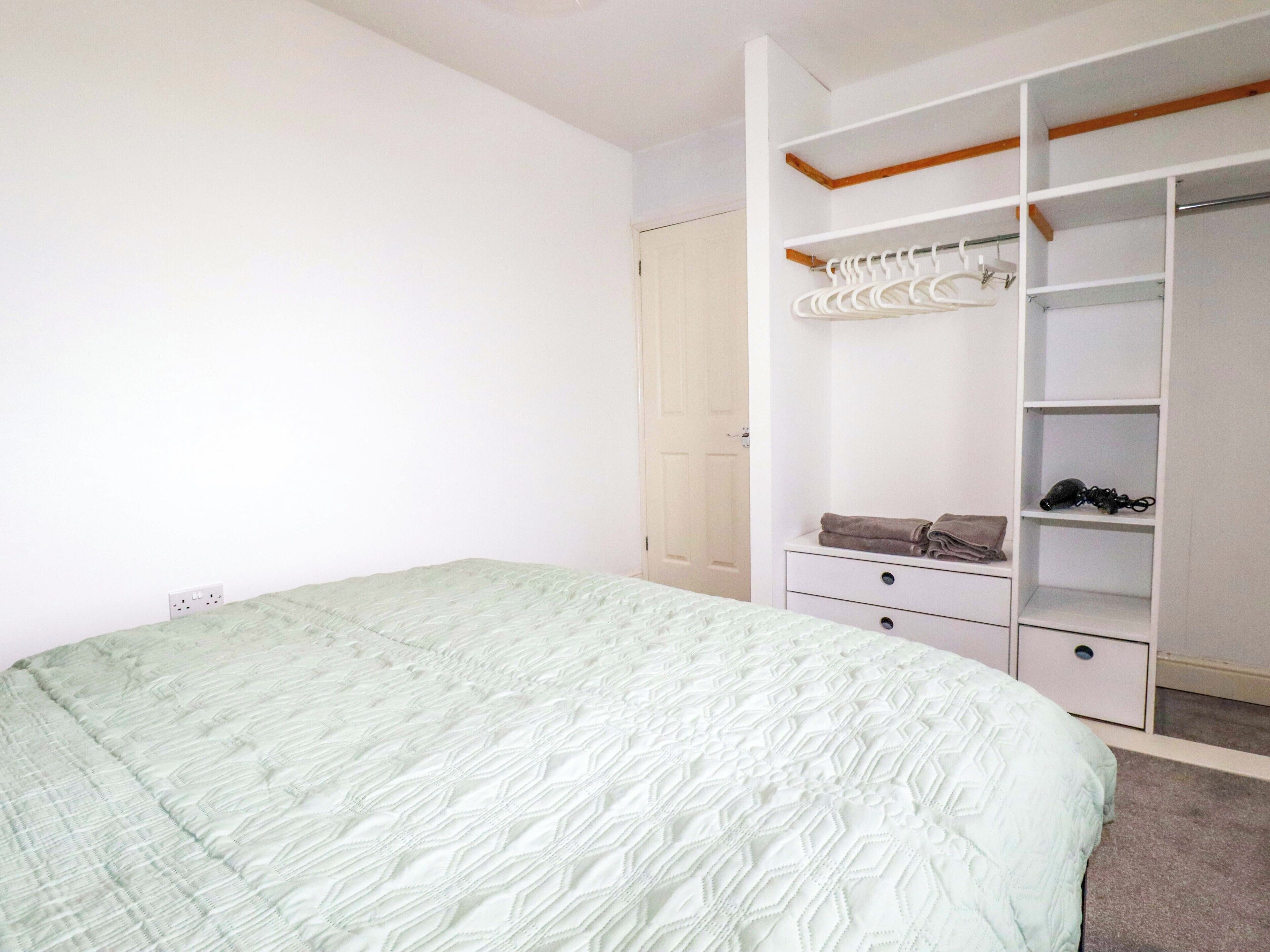 Un dormitorio con cama, armario y armario ropero.