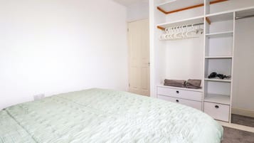 Un dormitorio con cama, armario y armario ropero.