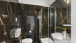Ein modernes Badezimmer mit Toilette, Duschkabine und Waschbecken.