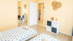 A room with two beds, a wardrobe, a mirror, and a small cabinet. - Nid des Étoiles, garden, 5 min Strasbourg (Oberhausbergen)