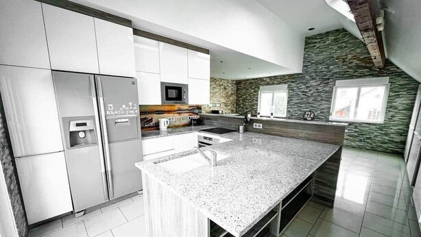 A modern kitchen with stainless steel appliances, a granite countertop, and a stone backsplash. - Villa with indoor pool (Holtzheim)